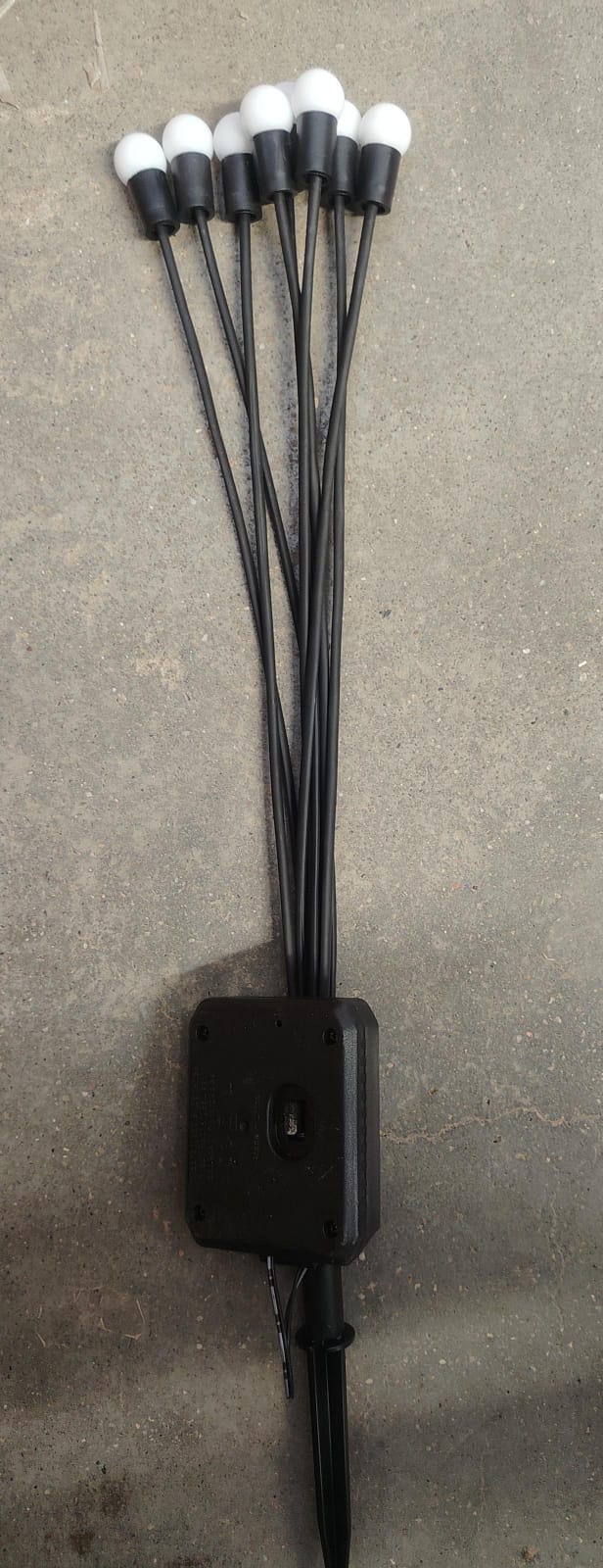 Solar powered garden light with glowing fiber optic strands in green lawn