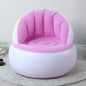 Child happily sitting on a bright yellow Kids Inflatable Sofa Chair with backrest.