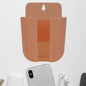 Wall mounted phone holder with a charging port in a modern living space.