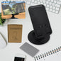 A sleek black rotating mobile stand, folded compactly on a desk, ready for use.