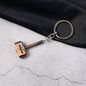 Metal Hammer Keychain with antique bronze finish on neutral background