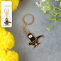 Golden Shivling keychain in metal with intricate design on plain background