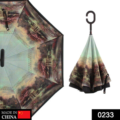 A partially open reverse umbrella with a dark landscape print, and a closed umbrella with a C-shaped handle.