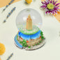 A beautifully crafted decorative snow globe featuring a festive scene, perfect for desk decor.