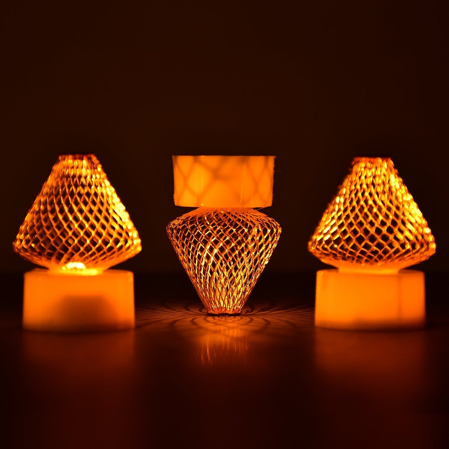 A close-up view of multiple Flameless LED Tea Light Candles glowing warmly on a dark surface.