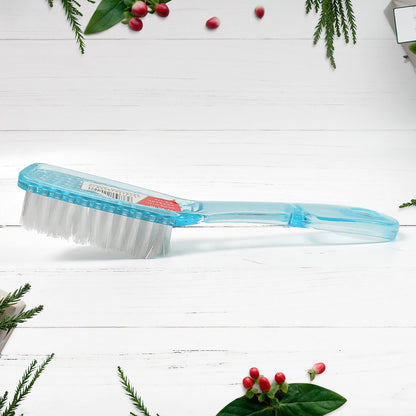 Ergonomic scrubbing brush being used to clean the sole of a shoe.