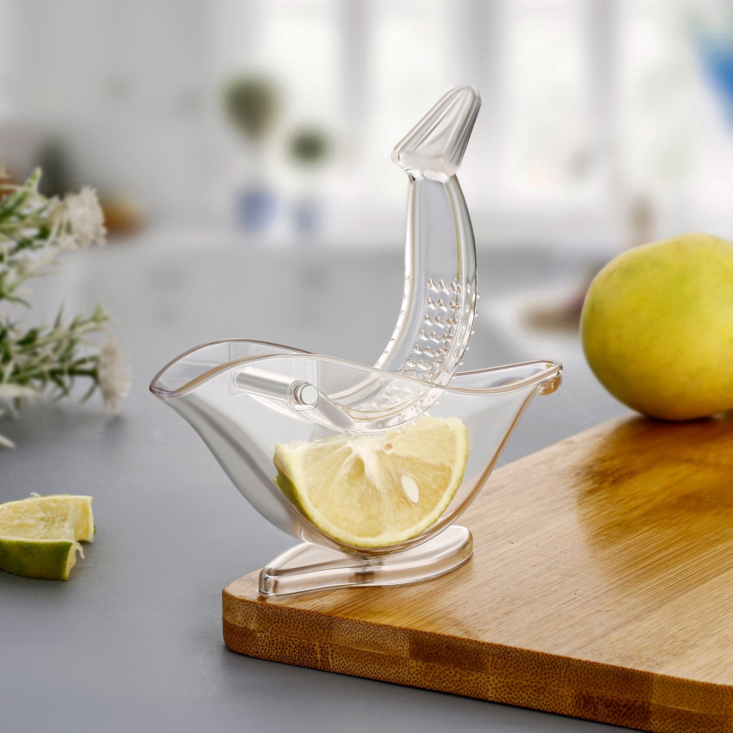 Hand holding the unique bird-shaped manual juicer over a glass.