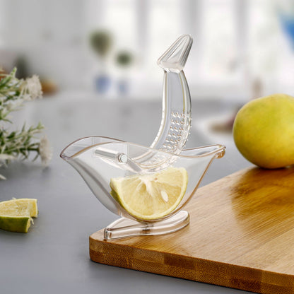 Hand holding the unique bird-shaped manual juicer over a glass.
