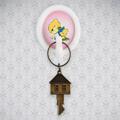 A smiley wall hook holding a kitchen ladle, demonstrating its functionality in a modern kitchen setting.