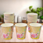 A stack of mixed design disposable paper cups ready for use at an Indian gathering.