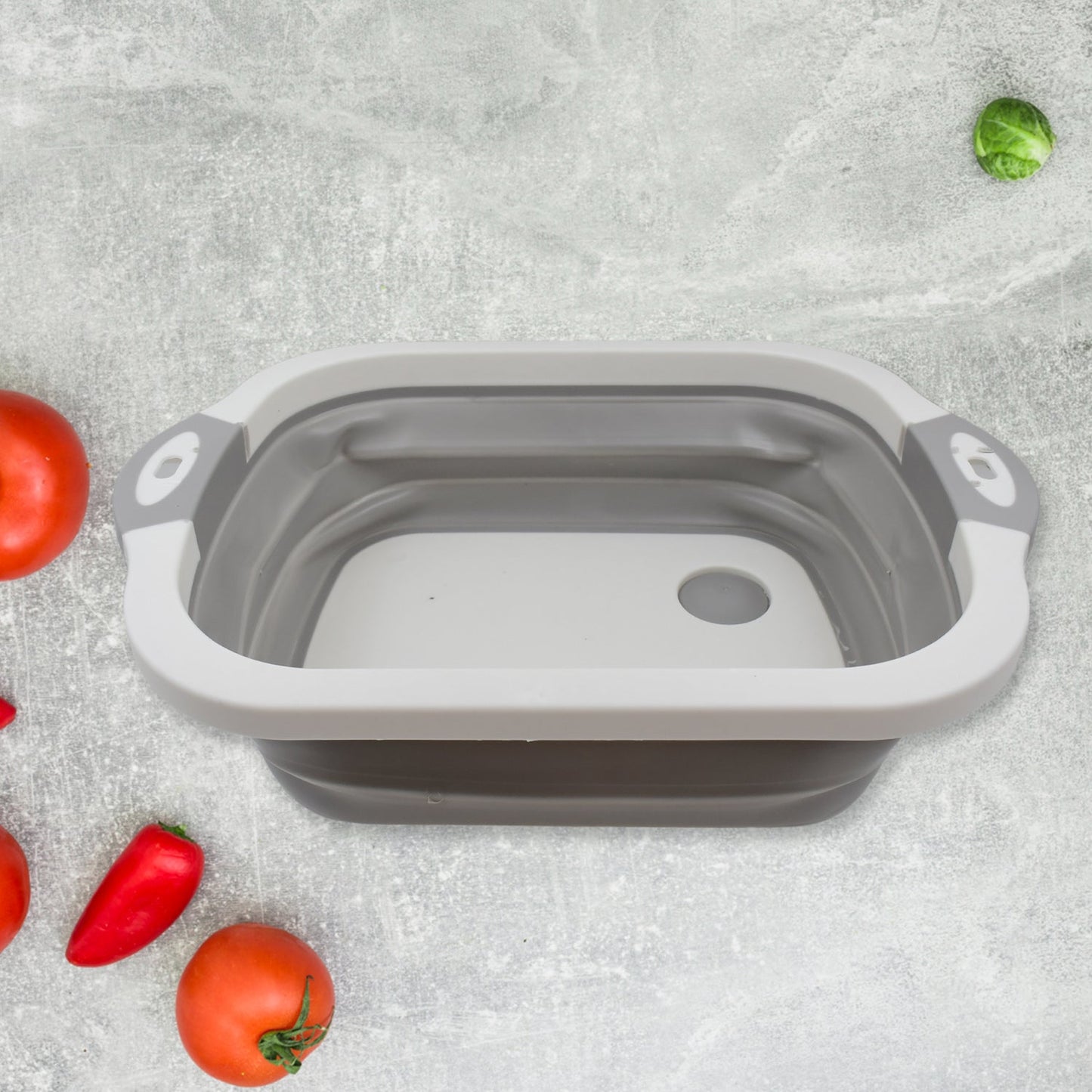 Collapsible cutting board folded for compact storage in a kitchen drawer.