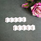 Set of 10 white plastic adhesive wall hooks for drill-free hanging.