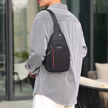 A person wears a black sling bag with red stripe and 'FASHION' label over a striped shirt, facing away.