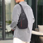 A person wears a black sling bag with red stripe and 'FASHION' label over a striped shirt, facing away.