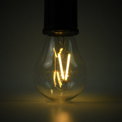 A close-up of the clear bulb of a portable LED tent light shows the glowing orange filament against a dark background.