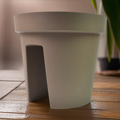 Creative flower pot holder mounted on balcony railing enhancing outdoor decor