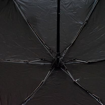 A DrizzlePro portable umbrella closed and ready to be stored, highlighting its compact design.