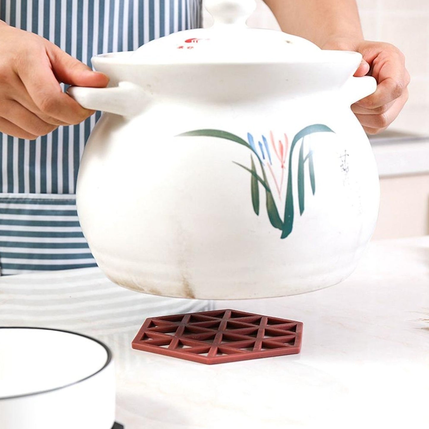Hollow design PVC mat used as a heat-resistant pot placemat in a kitchen.