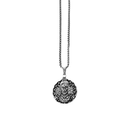 Close-up of a silver Hanuman Locket with intricate details.