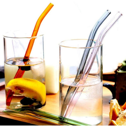 Five reusable clear glass drinking straws arranged side by side