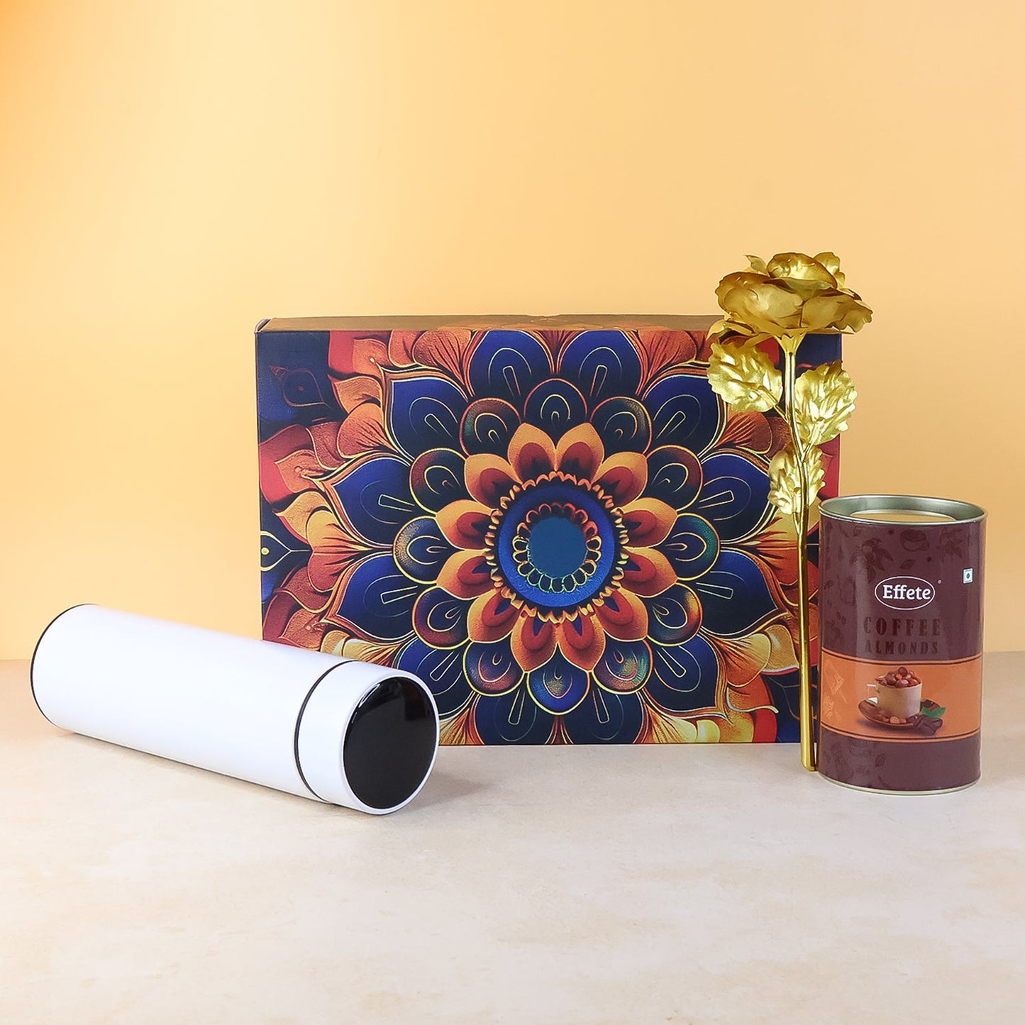 Festive gift hamper showcasing coffee almonds chocolate and stainless steel bottle with golden rose