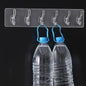 Transparent and golden 6-pin wall hook rail securely mounted on a white wall.