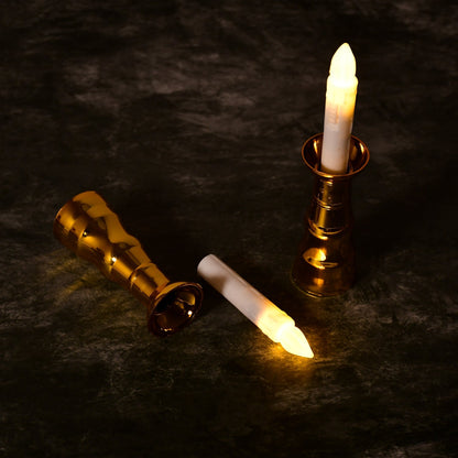 Close-up of a flameless LED candle light showing its realistic flicker and elegant gold base.