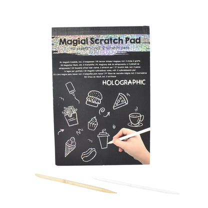 Child drawing detailed doodle on colorful scratch art sheet