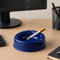 Dark blue plastic ashtray with wide bowl and 3 cigarette slots