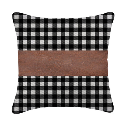A set of contemporary leather pillow covers arranged on a comfortable armchair.