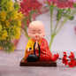 Front view of a solar Buddha statue with a gently moving head and hand, placed indoors.