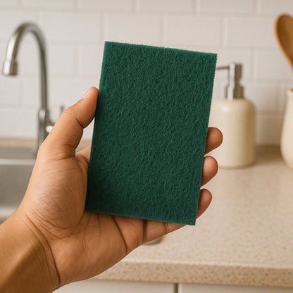 Kitchen scrubber pad in use cleaning cooking utensils