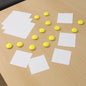Set of 10 white round fridge magnets on a metal surface, holding notes securely.