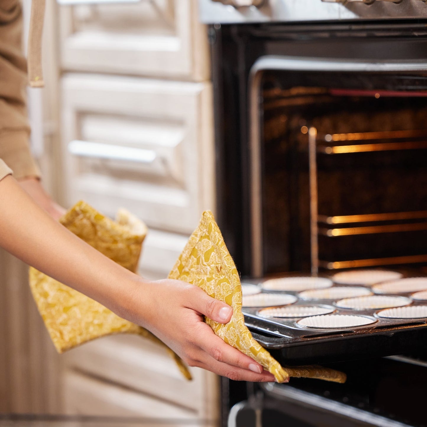 Multicoloured cotton oven mitt for safe kitchen handling.