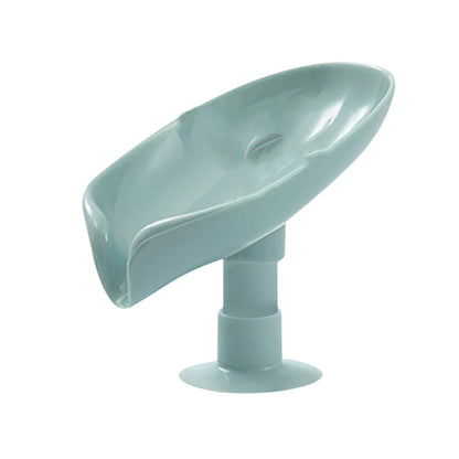 The self-draining soap holder demonstrating its water flow mechanism on a tiled surface.