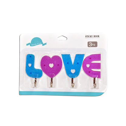 Multiple love shape self adhesive hooks organized on a kitchen wall.