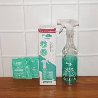 Spray bottle misting concentrated glass cleaner solution on glass surface for cleaning.