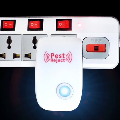A white ultrasonic pest repeller with a blue indicator light is plugged into a white power strip with red switches.