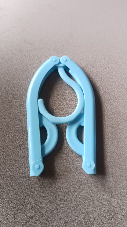 Single travel hanger shown in its fully compact, folded position for easy portability.