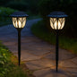 Two FitFuzion solar pathway lights illuminating a garden path with a unique water-ripple pattern at night.