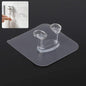 Transparent self-adhesive wall hook mounted on a clean, smooth wall.