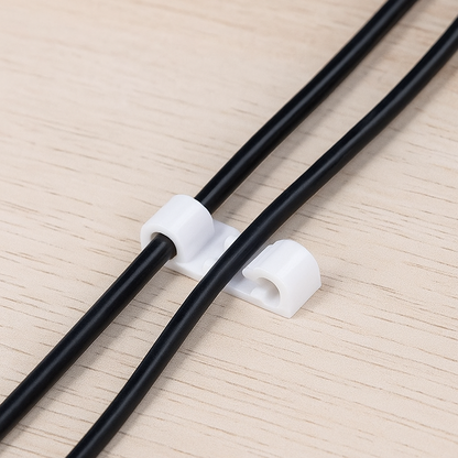 Multiple cable clips securing various power cords to maintain an organised workspace.