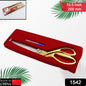Golden tailoring scissors with stainless steel blades precisely cutting a piece of fabric.