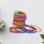 Multicolor rubber bands neatly arranged in a stack on a white surface.