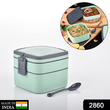 Side view of the green stackable lunch box with a spoon.