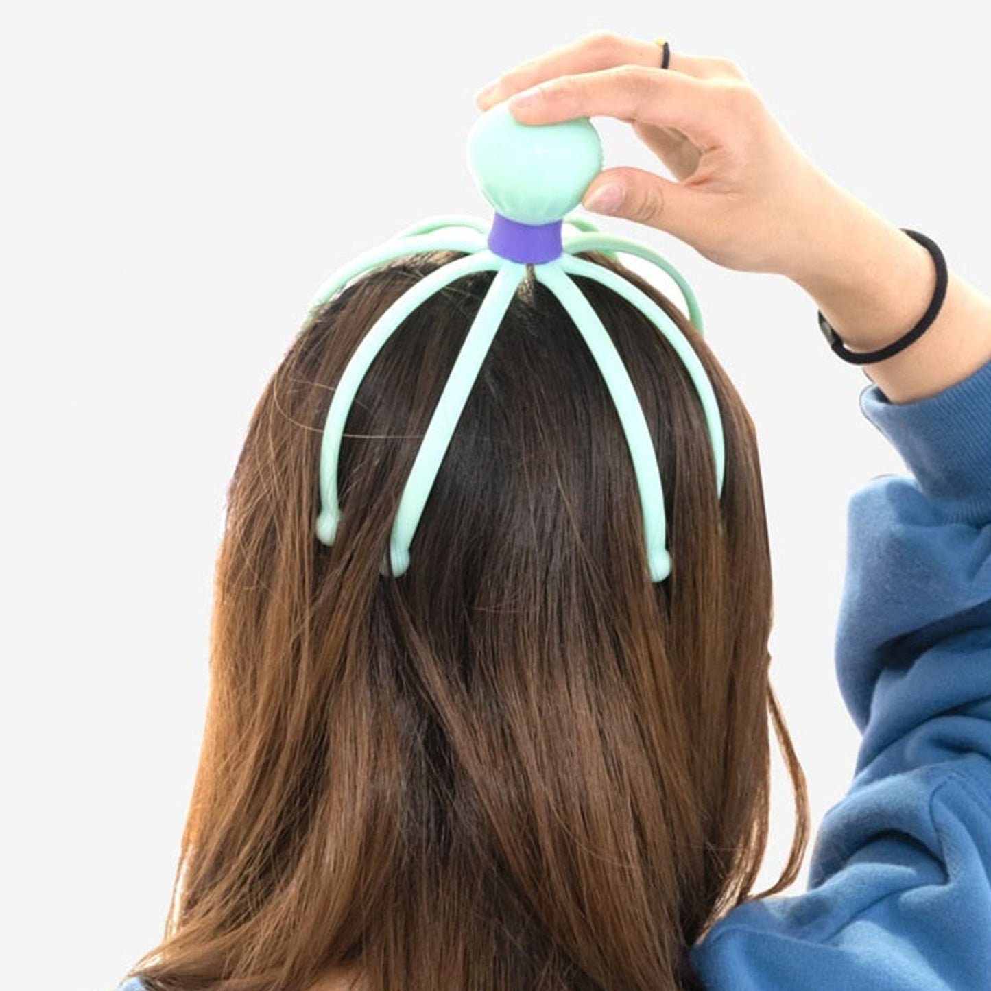 User demonstrating the stress relief scalp massager in action on their head.