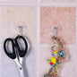 Pair of small stainless steel adhesive hooks on a white wall.