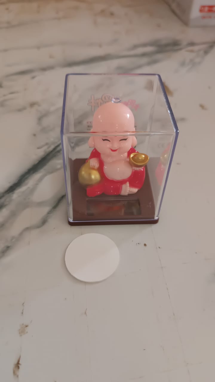Solar Buddha Car Ornament in natural light, demonstrating its automatic head movement.
