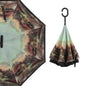 A reverse umbrella with a dark landscape painting on its inner surface, shown both partially open and closed.