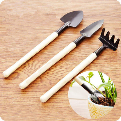 Kids Garden Tools Set of 3 pieces, including a yellow trowel, blue shovel, and green rake.